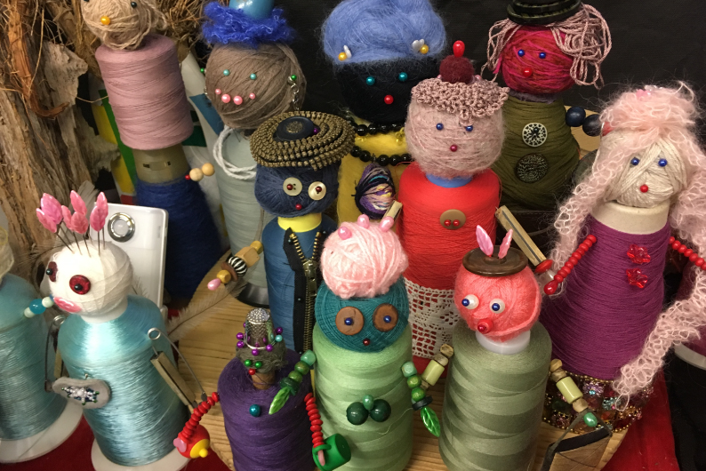 Nuotraukoje pavaizduotos lėlės iš siūlų ritinukų.